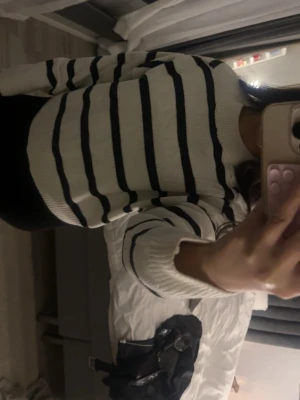 Vit stickad tröja med marinblå ränder - Säljer en vit stickad tröja med marinblå horisontella ränder. Tröjan har rund halsringning och långa ärmar. Den är mjuk och har en avslappnad passform, perfekt för dig som gillar klassisk och enkel stil. Storlek M som passar S också. 