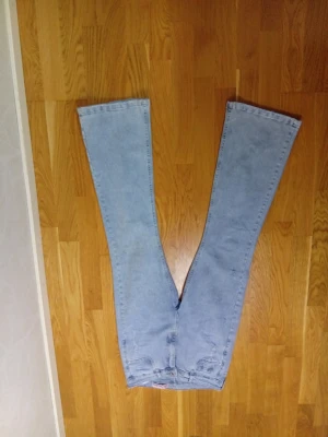 Ljusblå bootcut jeans - Säljer ett par ljusblå jeans med bootcut-modell och hög midja. Jeansen har klassisk femficksdesign och är tillverkade i ett mjukt denimtyg. Perfekta för dig som gillar retrostil och vill ha ett par riktigt snygga jeans med breda ben.