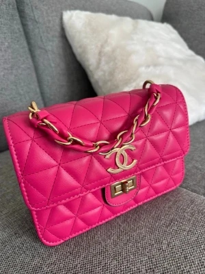 Rsa quiltad handväska - Säljer en ikonisk rosa quiltad handväska med guldfärgad kedja och klassiskt CC-spänne. Väskan är i läder och har en innerficka med dragkedja samt plats för det viktigaste. Perfekt accessoar för att lyfta din outfit.