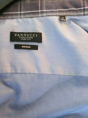 Ljusblå slim fit skjorta Vannucci - Snygg ljusblå skjorta från Vannucci Collection i slim fit-modell. Skjortan är tillverkad i 100% bomull och är non iron, vilket gör den enkel att sköta. Perfekt för dig som gillar en stilren och klassisk look.