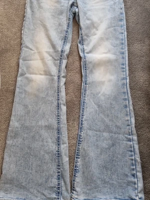 Ljusblå Freja jeans - Säljer ett par ljusblå jeans med utsvängda ben och medium midja. Jeansen har en tvättad look och är tillverkade i klassiskt denimtyg. Perfekta för dig som gillar retrostil och vill ha ett par riktigt snygga jeans.