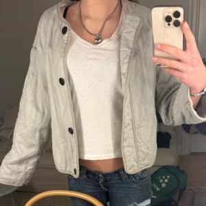 Ljusgrå/grön  quiltad jacka med knappar från Zara - Quiltad ljusgrå jacka med stora svarta knappar framtill. Jackan har en rak passform och är långärmad. Kontakta för mer info 💓