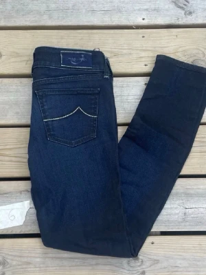 Herr Jacob Cohen jeans blå - 29-31 - Mörkblå jeans från Jacob Cohen med skinny passform. Klassisk femficksmodell med silverfärgade detaljer och snygg kontrastsöm på bakfickorna. Jeansen har normal midja och är tillverkade i stretchig bomullsdenim för en bekväm känsla. Sitter som 29-31 