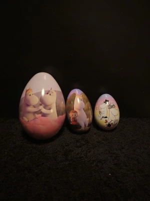 Mumin påskägg i plåt - Säljer färgglada påskägg i plåt med olika Mumin-motiv. Äggen har motiv av Muminfamiljen, Lilla My, Snusmumriken och andra karaktärer från Mumindalen. Perfekta att fylla med godis eller små presenter. Äggen är i olika storlekar och har fina illustrationer. 100kr för de små (15cm) 120kr för mellan (18cm) och 180kr för de stora (180kr). Dom kan fraktas men då på egen kostad! 