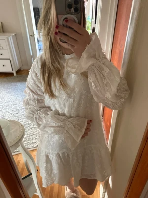 Klänning från NAKD - Aldrig använd, Söt vit kortklänning från NAKD i spets med blommigt broderi och volangdetaljer. Perfekt till student eller skolavslutningen🌸stl 36
