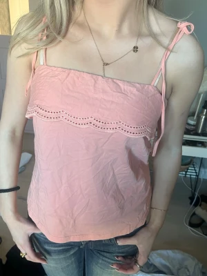 Ljusrosa linnetopp med spetsdetalj - Söt ljusrosa linnetopp med tunna axelband som knyts på axlarna. Så går att justera så att den sitter snyggt!!💕