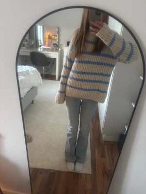 Beige stickad tröja med blå ränder - En beige stickad tröja med blåa ränder från Vero Moda i storlek S. Knappt använd, som ny.
