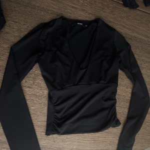 V-ringad svart topp, BIKBOK - V-eingad svart topp från bikbok. Använt fåtal gånger, fint skick!