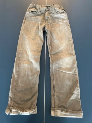 Grå raka jeans replay  - Säljer ett par grå jeans med raka ben. Jeansen har klassisk femficksdesign och normal midja. de har en avslappnad look som passar till det mesta. Perfekta för dig som gillar en enkel men trendig stil.