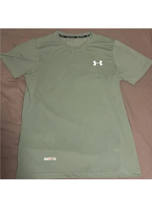 Under Armour  - Riktigt snygg grön t-shirt från Under Armour med klassisk logga på bröstet. Först till kvarn!