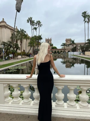 Skims klänning - Elegant svart långklänning med smala axelband och figurnära passform. Klänningen har en enkel och stilren design som framhäver siluetten. Perfekt för dig som gillar minimalistisk stil och vill ha en klassisk look.