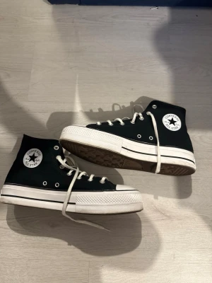 Svarta! Converse Chuck Taylor High - svarta Converse Chuck Taylor All sop High med vit tå. Skorna  har vita snören, metallöljetter och den ikoniska loggan på sidan. Ovandelen är i canvas och sulan i gummi. Perfekta för dig som vill ha en tidlös sneaker med retrovibe. Priset kan självklart diskuteras 