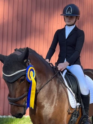 Svart tävlingskavaj Cavalleria Toscana - Säljer en svart tävlingskavaj från Cavalleria Toscana, perfekt för juniorer som rider. Kavajen har klassisk passform med tre knappar framtill, snygga fickor och är tillverkad i ett stretchigt material som ger bra rörelsefrihet. Stilren och modern design.