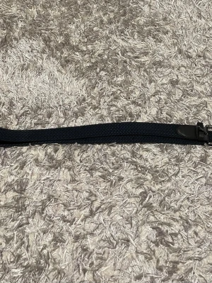 Mörkblått flätat bälte - Snyggt mörkblått flätat bälte med detaljer i skinn. Perfekt för att ge din outfit en stilren touch. Bältet har ett klassiskt spänne i metall och passar till både jeans och chinos.