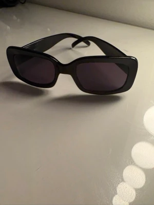 Fyrkantiga svarta solglasögon - Supersnygga solglasögon med svarta bågar och fyrkantiga glas. Vet ej vartifrån, fått från mormor