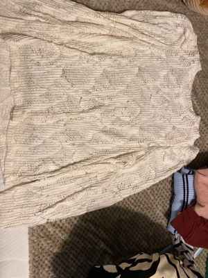 Vit spetsblus med lång ärm - Snygg vit blus i spets med långärmad design och rund halsringning. Blusen har ett vackert mönster i spetsmaterial som ger en romantisk och trendig känsla. Perfekt att styla med jeans eller kjol för en cool look.