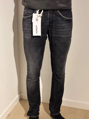Svarta slim jeans från Dondup - Snygga svarta jeans i slim fit-modell från Do. Jeansen har klassisk femficksdesign, smal passform och är tillverkade i ett stretchigt jeanstyg som sitter tajt längs benen. Perfekta för dig som gillar en stilren och modern look.