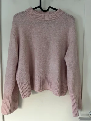 Ljusrosa stickad tröja Gina Tricot - Mysig ljusrosa stickad tröja från Gina Tricot med bred ribbad mudd. Modellen är lite kort i längden men i super bra skick Storlek 146/152 