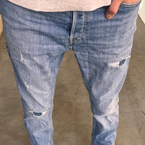 Jack and Jones jeans  - Ett par riktigt feta Jack and Jones jeans med slitningar och i bra skick🥳🤩 dessa jeans är i storlek 29/30🏆Vid minsta fundering är det bara att kontakta mig!🤩