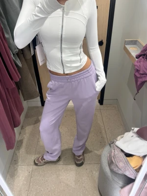 Lululemon Ljuslila mjukisbyxor med raka ben - Säljer ett par ljuslila mjukisbyxor med raka ben och resår i midjan. Byxorna har sidofickor och är gjorda i ett mjukt, bekvämt material som känns skönt mot huden. Perfekta för en chill och avslappnad stil när man fortfarande vill känna sig put together💞 Nypris 1380kr