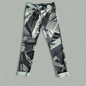 DKNY Jeans Skyline Skinny med print - Snygga skinny jeans från DKNY Jeans med unikt svartvitt stadsmotiv över hela byxan. Modellen är smal och har klassiska fem fickor samt uppvikta benslut. Perfekt för dig som vill sticka ut med ett coolt grafiskt mönster.