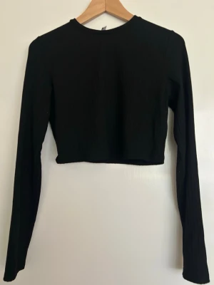 Svart ribbad croptop från NLY Trend - Enkel och stilren topp som är lätt att matcha till jeans, kjol eller mjukisbyxor. Passar perfekt till vardag eller fest.  Toppen är i fint skick och har använts få gånger.
