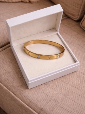18K guld pläterade armband  - Snyggt guldfärgat armband i metall med infällda klara stenar och ingraverade symboler runt om. Armbandet har en stilren och modern design som passar perfekt till din accessoar-samling.