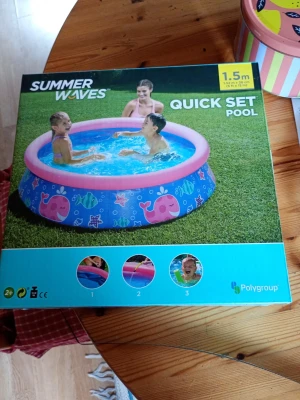 Uppblåsbar barnpool Summer Waves - Säljer en rund uppblåsbar pool från Summer Waves, 1,5 meter i diameter. Poolen är blå med rosa kant och har färgglada motiv av fiskar och valar. Perfekt för varma sommardagar och enkel att sätta upp i trädgården.
