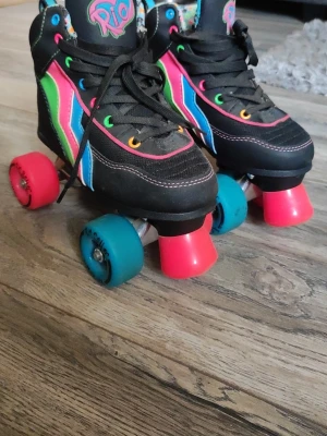 Färgglada rullskridskor från Rio rollers  - Strl 33 Rullskridskor som blivit använda väl. Har några få defekter som syns på sista bilden (tungan är missfärgad). Annars fungerar de precis som de ska och är jättefina!