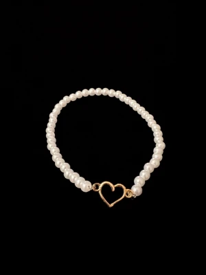 ”White Love” Armband med vita pärlor med ett guldigt hjärta - Snyggt armband med vita pärlor och en guldfärgad hjärtformad detalj i mitten. Perfekt accessoar för att lyfta din stil med en romantisk touch. Elastiskt band gör det enkelt att ta på och av.