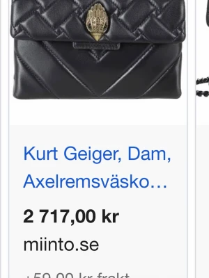 Svart quiltad axelväska Kurt Geiger - Snygg svart axelväska från Kurt Geiger i quiltat läder med guldfärgad kedjerem och ikonisk örndetalj på locket. Väskan har en stilren, rektangulär form och elegant finish som gör den till ett statement i varje outfit. Köpt för 2717kr❣️
