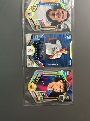 FIFA 365 fotbollskort holografiska - Tre FIFA 365 fotbollskort med holografisk finish, färgstark design och spelare från England, Real Madrid och Barcelona. Kortens form är unik och de har detaljerade stats och klubbmärken. Perfekt till samlingen för dig som älskar fotboll och samlarkort.