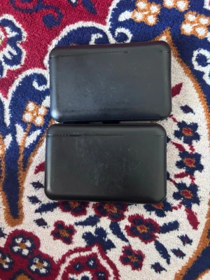 Svarta powerbanks med USB-portar - Två svarta powerbanks i plast med rundade hörn och enkel design. Båda har två USB-portar och en micro-USB-port för laddning. Perfekt för att ladda mobilen eller andra enheter när du är på språng. OBS! Kan bara mötas och i Stockholm!