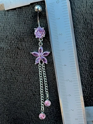 NY oanvänd Navelpiercing med långt hänge | Kirurgiskt stål | Blomma, kedjor och rosa stenar  - 💕30% Bundle-rabatt vid köp av minst 2 artiklar. ⭐️NY oanvänd piercing i kirurgiskt stål; rostfritt och säkert för läkta piercingar.                               📏MÅTT ⭕️Stavens längd: 10mm ⭕️Stavens tjocklek: 1,6mm ⭕️Smyckets totala längd: 80mm                                                                         🤍Färger: Silver och rosa                                                            💌Skickas spårbart via Plick SafePay.