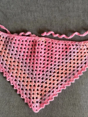 Rosa bandana - Söt handvirkad bandana i rosa och lila toner med hålmönster och vågig kant. Perfekt att knyta runt huvud/ halsen för en färgklick till din outfit. Mjuk och lätt, gjord i garn som känns skönt mot huden.