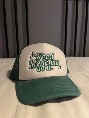 Grön och vit truckerkeps, Ted Wonti - Snygg truckerkeps i grönt och vitt från Ted Wonti med broderad text 'Wonti Made me do it.' på framsidan och ett litet W på sidan. Perfekt för en cool och avslappnad stil.