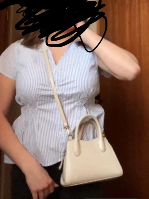 Vit/ beige handväska  - Fin vit handväska från HM, med handtag som är böjda. Passar till sommarfärger. Den har en fläck inuti väskan som syns om man kollar, den luktar inte konstigt alls