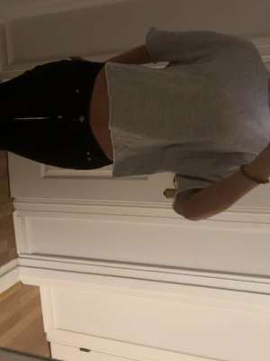 Grå croppad t-shirt - Säljer en enkel och stilren grå croppad t-shirt med korta ärmar. T-shirten har en avslappnad passform och är tillverkad i mjuk bomull, perfekt för en chill och trendig look.