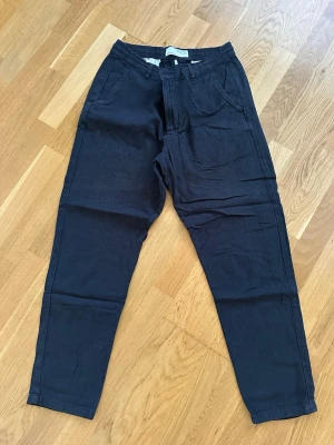 Svarta mjukisbyxor från Selected Homme - Svarta mjukisbyxor från Selected Homme med elastisk midja och klassisk rak passform. Byxorna har sidfickor och är tillverkade i ett mjukt och bekvämt material som passar perfekt för en avslappnad stil.