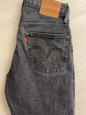 Stonewashed Levi's raka jeans - Säljer ett par grå raka jeans från Levi's med klassisk femficksdesign och ikonisk röd logotyp på bakfickan. Jeansen har hög midja och är tillverkade i kraftig denim. Jättefint skick samt inga fläckar eller defekter 