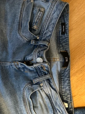 Blå jeans från LTB - Säljer ett par klassiska blå jeans från LTB, modell VALERIE. Jeansen har fem fickor och snygga kontrastsömmar. Tillverkade i mjukt denimtyg som sitter bekvämt och passar perfekt till en avslappnad stil.