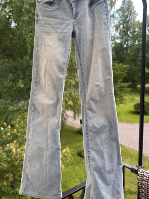 Ljusblå bootcut jeans - Ljusblå jeans med gulliga detaljer på fickan. Har en liten fläck på baksidan längst ner på byxorna men det är inget som märks🤩🤩