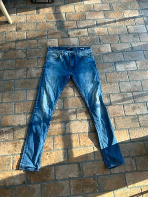 Replay slim jeans - Snygga blå slim fit jeans med klassisk femficksdesign och dragkedjegylf. Jeansen har en tvättad look och smala ben som ger en modern siluett. Perfekta för dig som gillar en avslappnad men trendig stil. Materialet är denim i bomull. 32/34 i storlek. Passar perfekt på lite mindre dock.