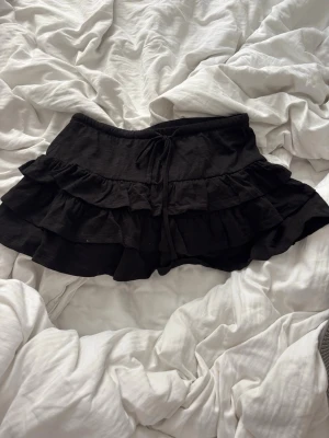 Svart volang kjol  - Supersöt svart Lågmidjad volang kjol ifrån Gina, säljer denna då den aldrig är använd den är helt ny med prislappen på💗