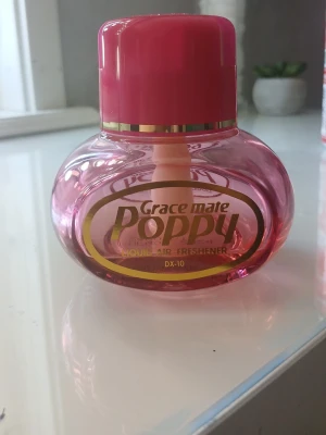 Grace Mate Poppy luftfräschare rosa - NÄSTAN SLUT❤️ Säljer en Grace Mate Poppy luftfräschare i genomskinlig rosa plast med guldfärgad text och detaljer. Flaskan har en rund form och ett rosa lock. Perfekt för att fräscha upp rummet eller bilen med en fräsch doft.
