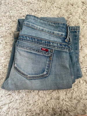 Ljusblå raka jeans från Only - Säljer ett par ljusblå jeans från Only med klassisk femficksdesign och raka ben. Jeansen har en snygg tvättad look, silverfärgade knappar och detaljer samt en liten röd Only-lapp på bakfickan. Perfekta till en avslappnad stil. Insydda till storlek S/W26 men om man sprätter upp sömmarna blir de storlek W32