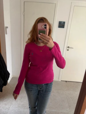 Rosa långärmad topp från Ralph Lauren  - Säljer en rosa långärmad topp från Ralph Lauren  med rund halsringning. Toppen har en liten logga på bröstet och är i ett mjukt bomullsmaterial. Perfekt till jeans eller kjol för en enkel och snygg look.