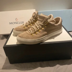 Beige mockasneakers från Diemme - Snygga beige sneakers från Diemme i mjuk mocka med vita snören och guldfärgade metalldetaljer. Skorna har en platt vit sula och rund tå, vilket ger en clean och modern look. Perfekta för dig som gillar exklusiva material och stilrena detaljer. Passar som storlek 42