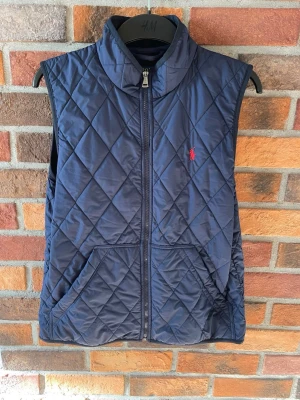 Ralph Lauren väst (176) - Marinblå Polo Ralph Lauren väst i mycket bra skick 👏 | Självklart är den äkta ✅ | Storlek XL i junior (18-20) ungefär XS 📏 | Vid funderingar bara att skriva ✍️ | Frakt inom 48h 📦