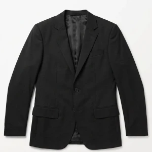 Klassisk svart kavaj med enkelknäppning - Stilren svart kavaj med enkelknäppning och två fickor framtill. Kavajen har smal passform, klassisk krage och helfodrad insida. Perfekt för en dressad look och passar till många olika stilar.